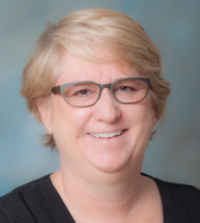 A picture of Lisa, she is wearing a black blouse and glasses